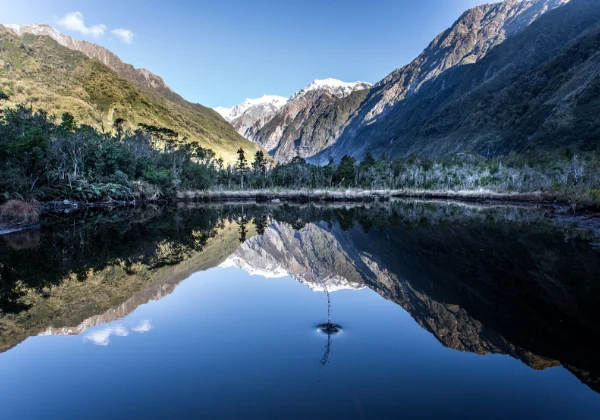 Very still lake reflecting the snowy