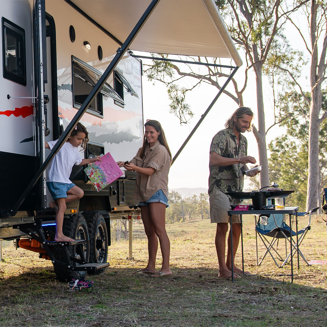 Family outside a wild caravan, enjoying the natural surroundings and spending quality time together in a rustic setting