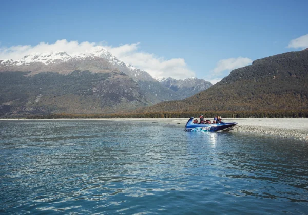jet boat on a lake in front of snowy mountains