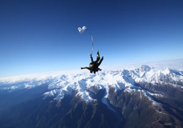 Skydivers with snow capped mountains filling the view