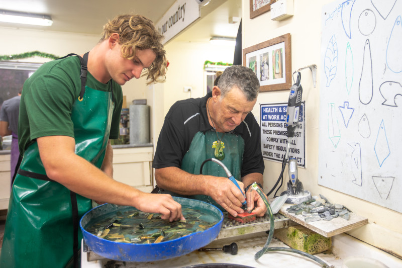 A young couple showing the Pounamu they carved and turned to necklaces