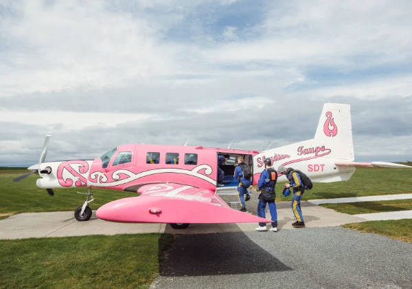 Small plane on the runway with skydivers boarding
