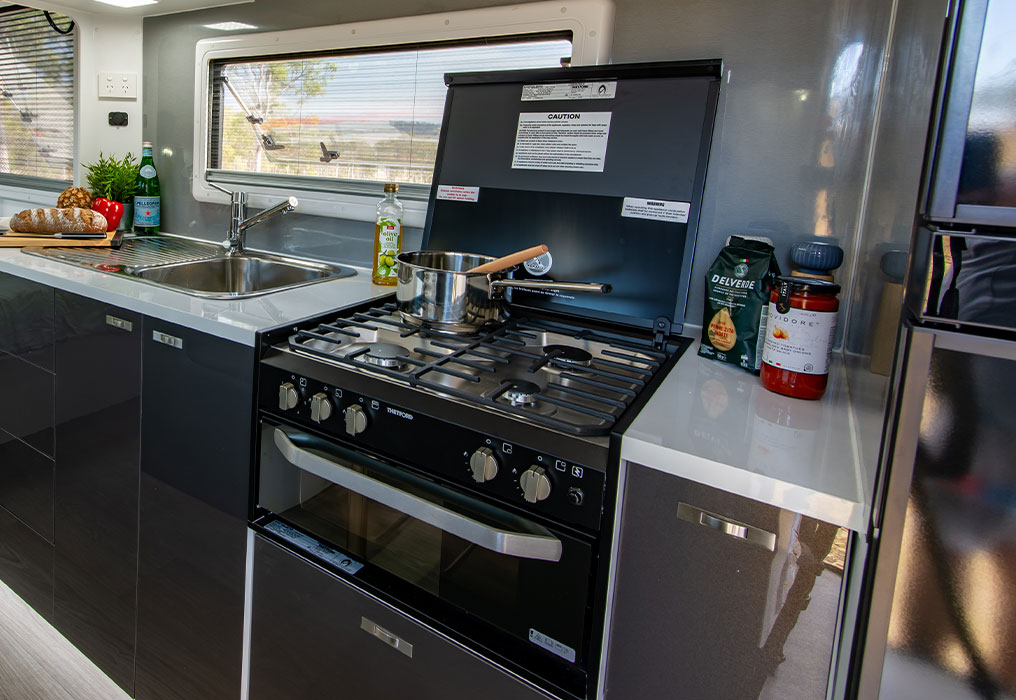 Compact interior setup displaying AC, stove, and washing machine, showcasing efficient use of space.