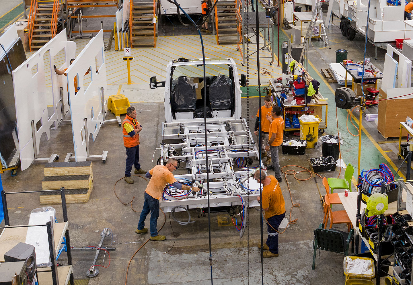 Image of the Winnebago warehouse with workers assembling the bare chassis of a Winnebago motorhome showcasing the innovation, quality and craftsmanship of Winnebago Australia.