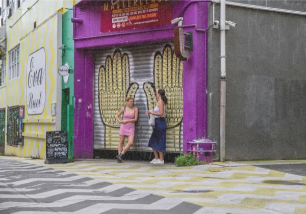 2 woman posing in front of some urban art