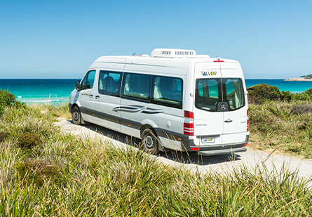 Talvor Euro Tourer Campervan parked in front of a picturesque blue ocean, grass on either side of the RV.