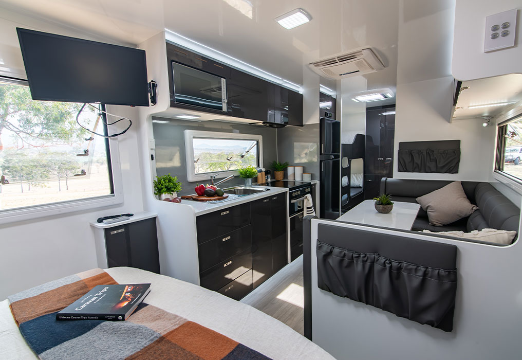 Interior view featuring kitchen, dinette, and bed options, highlighting versatile and functional living spaces.