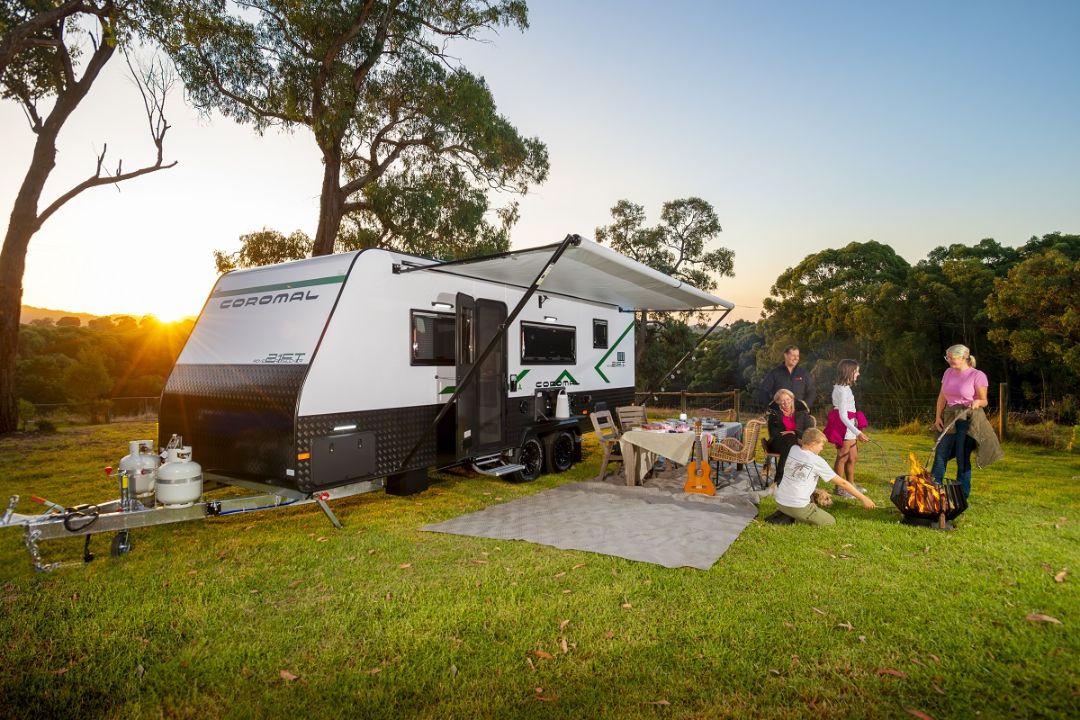 Coromal Adventure Seeker caravan parked at a Batemans Bay campsite, with a family enjoying the sunset.