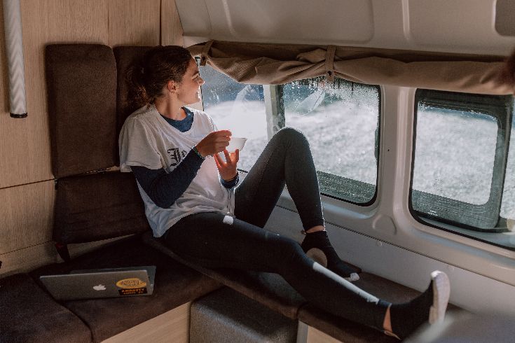 Couple camping in front of their camper Couple camping in front of their camper