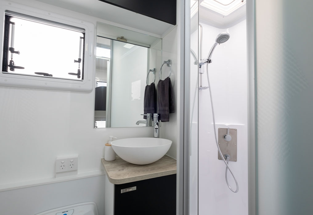 Full-size ensuite featuring a fully enclosed shower and electric flush toilet, showcasing modern amenities and spacious design