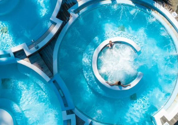 Hot water pool pouring being enjoyed by 2 people relaxing