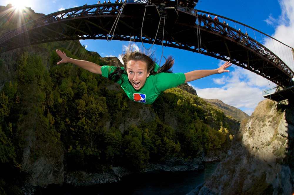 Person mid-bungy jump from a bridge