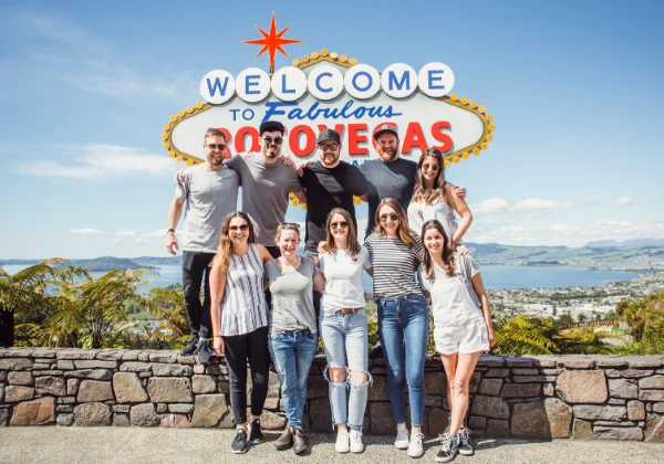 A large group of people posing in front of the Rotorua Welcome sign