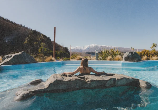 Sitting in a hot pool with views of snow covered mountain ranges