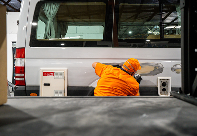 Service Technician Working on the Exterior Body Lower Panel of a Motorhome