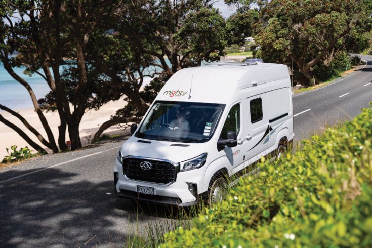 Couple camping in front of their camper
