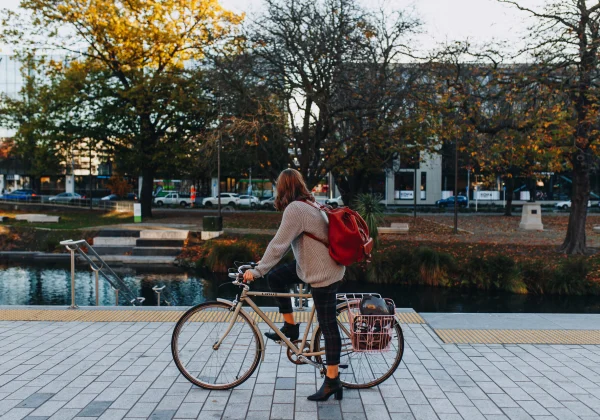 Peron on a bicycle looking at a river in an urban setting
