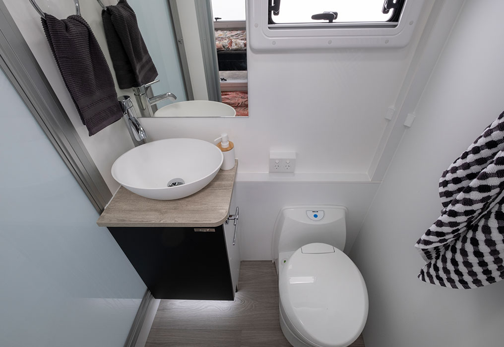 Separate full-size ensuite featuring a shower and electric flush toilet, showcasing a spacious and modern bathroom setup