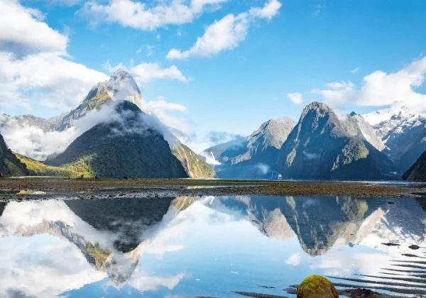 Smooth lake reflecting snowy mountains
