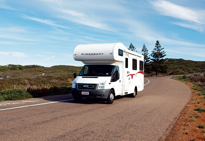 Winnebago motorhome driving on a rural Australian road.