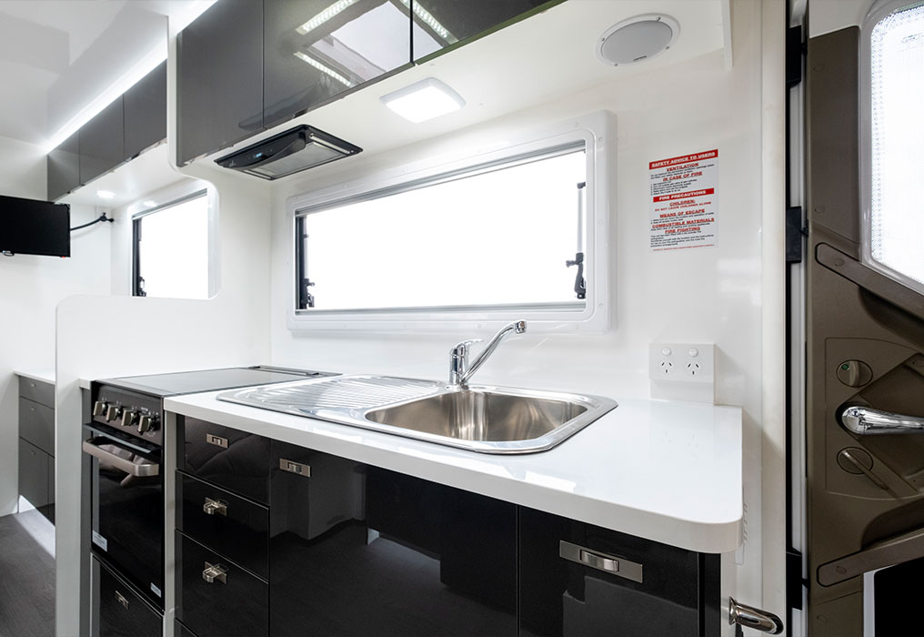 Kitchen featuring a sink, benchtops, and ample storage, showcasing a functional and organized cooking area.