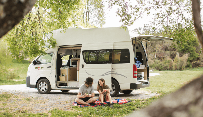 Couple camping in front of their camper