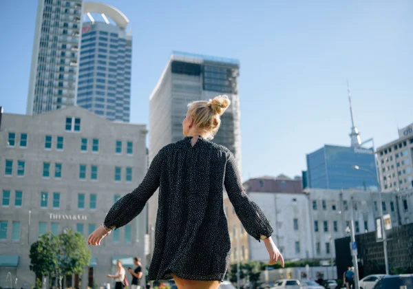 Lady walking through auckland city, with her back to the camera, looking upwards
