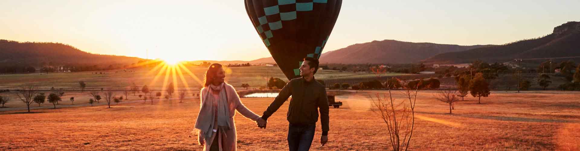 Couple walking in front of hot air balloon