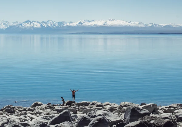 Rocks, lake, snow covered mountains