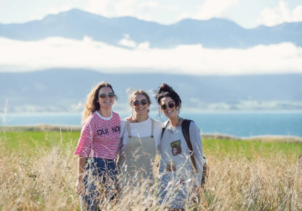 Three friends posing with a mountain range in the distance