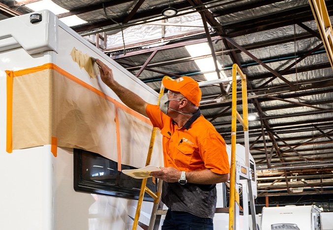 Service Technician Working on the Exterior Body of a Motorhome