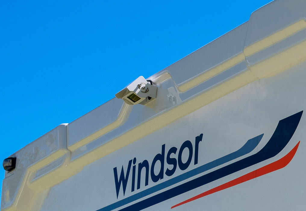 Close-up of a motorhome with a reversing camera and a solar panel, highlighting safety and sustainable energy features.