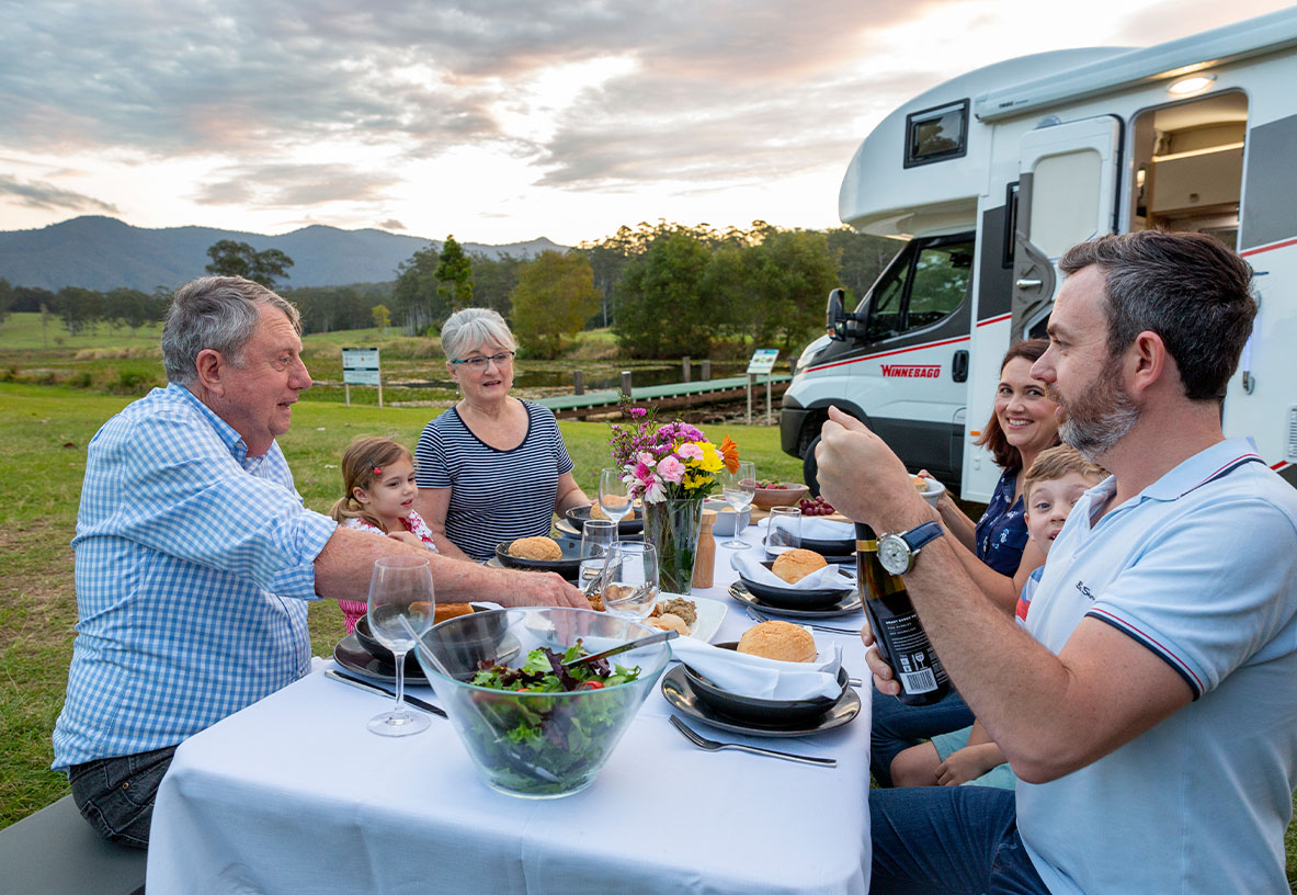 a family enjoying a meal outside of their motorhome